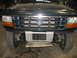 1995 Ford C-350 (Centurion Conversions) - Front view of a green Ford truck, revealing its grille, headlights, and intercooler assembly.