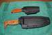 1991 Ford Bronco - Two knives, one with an orange handle and the other with a wood handle, are shown in their black sheaths on a teal towel.