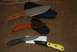 1991 Ford Bronco - A collection of knives with various handle colors and blade styles are laid out on a textured brown background.
