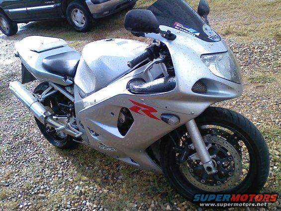 2003 Suzuki GSX-R600 sportbike parked on gravel, with two SUVs in the background
