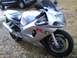 2003 Suzuki GSX-R600 - Silver 2003 Suzuki GSX-R600 sportbike with red 'R' logo, parked outdoors near SUVs.