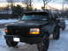 1995 Ford Bronco - A black 1995 Ford Bronco is parked in the snow, equipped with a light bar and smiley face lights.