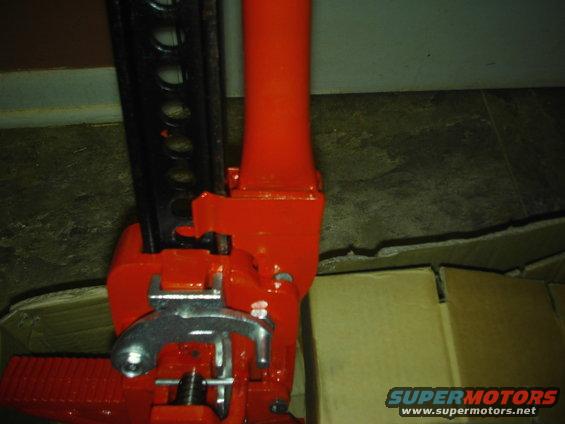 Red and black hi-lift jack with a metal lifting mechanism
