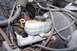 1990 Ford Bronco - Close-up view of the brake master cylinder and fluid reservoir within a vehicle's engine bay.