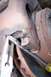 1990 Ford Bronco - A close-up view of a vehicle's brake rotor and caliper assembly, with tools being used for maintenance.