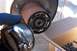 1990 Ford Bronco - A chrome locking hub, labeled "WARN LOCKING HUB", is held near a rusty wheel hub assembly.