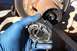 1990 Ford Bronco - A close-up view of a damaged manual locking hub, showing its internal gears and a gloved hand holding it.