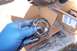 1990 Ford Bronco - A mechanic holds a heavily greased and worn wheel bearing, likely removed from a vehicle's axle assembly.