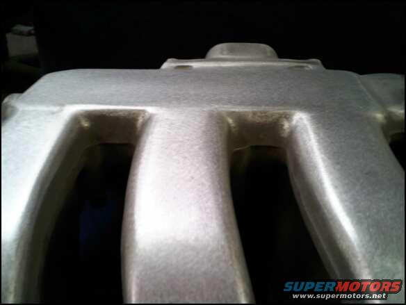 Close-up of a silver aluminum intake manifold with multiple runners