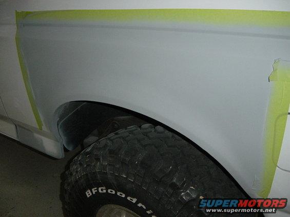 White vehicle fender with masking tape, showing a BFGoodrich tire. Appears to be a 1992 Ford Bronco