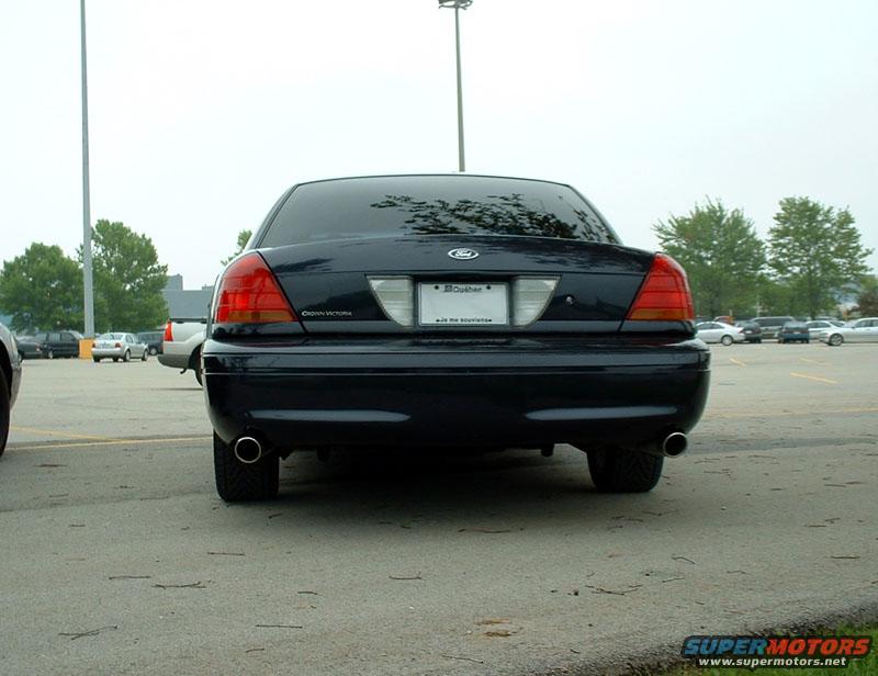 Dark blue 2000 Ford Crown Victoria rear view in a parking lot. Other cars and trees visible