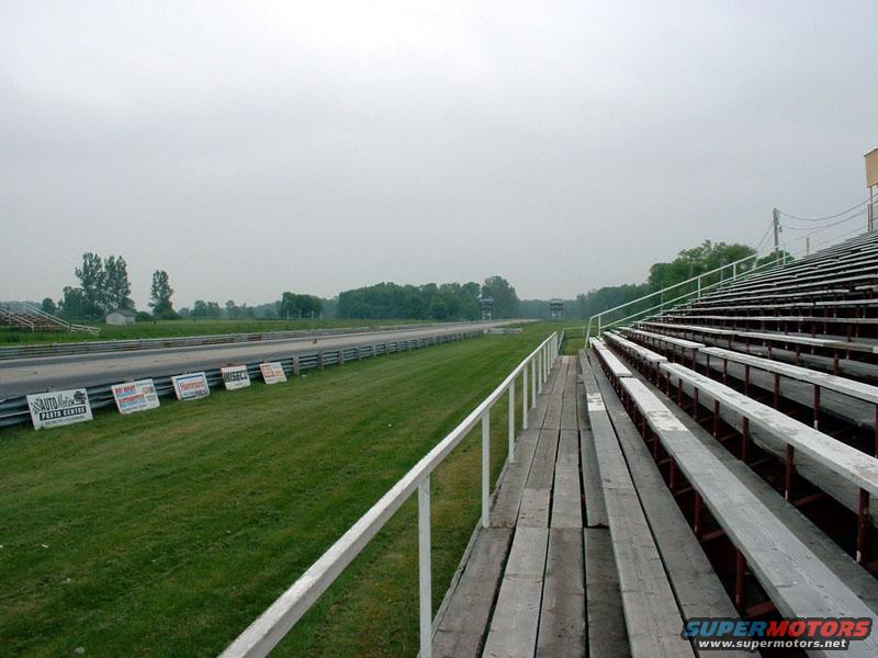 Drag strip with bleachers and signs along the track