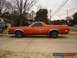 1971 Ford Ranchero - Side view of an orange 1971 Ford Ranchero parked on a street with trees in the background.
