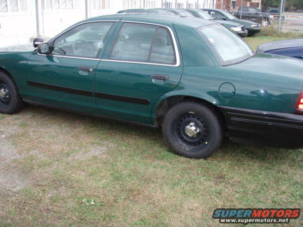 Side view of a green sedan with black trim and steel wheels. It appears to be a 1998 model