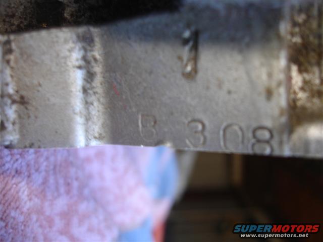 Metal casting with stamped numbers B 308 and a single digit 1