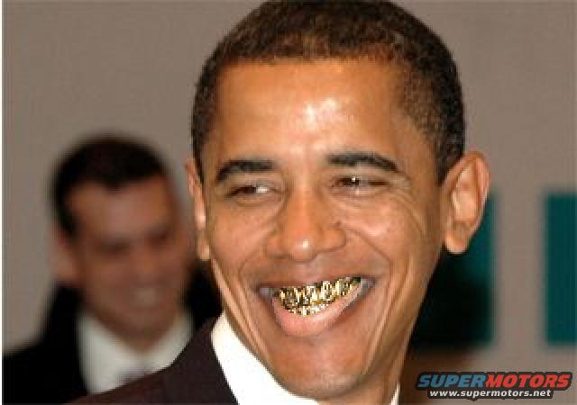 Barack Obama smiling with gold teeth grills. Another person is blurred in the background. Supermotors.net logo in lower right