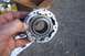 1990 Ford Bronco - A person holds a metal automotive part, likely a locking hub, with visible splines and gear teeth.