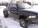 1995 Dodge 3500 - A black dually pickup truck with a camper shell is parked in the snow.