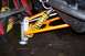2004 Arctic Cat F-7 Firecat - Close-up view of a snowmobile's front suspension system, orange A-arms and a yellow coilover shock.