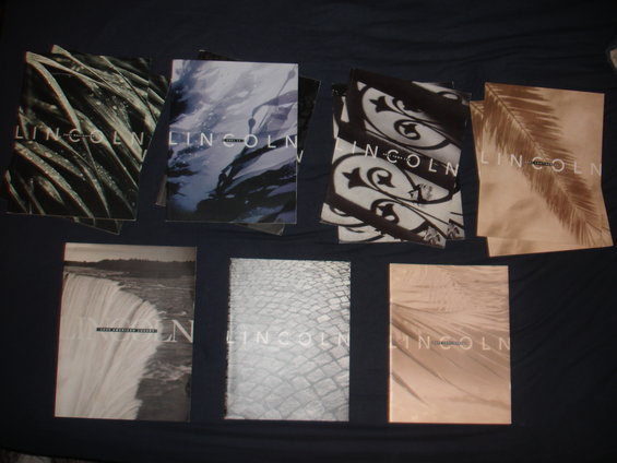 Several Lincoln brochures with nature-themed covers, including leaves and water