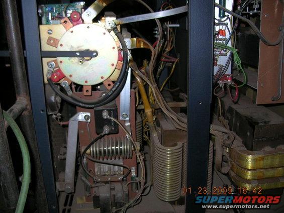 Internal view of a welding machine showing transformer coils, wiring, and a rotary switch