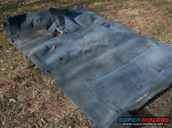 Blue automotive carpet with holes and stains