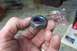 1990 Ford Bronco - A hex nut with blue threadlocker is held in a hand, with a plastic bag and papers in the background.