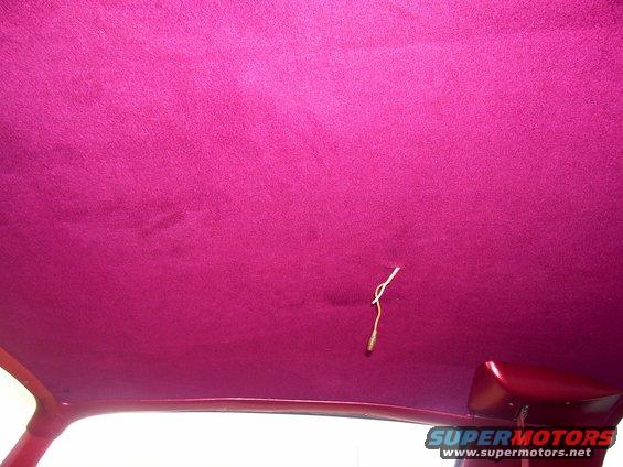 Car interior headliner with pink upholstery and exposed wiring