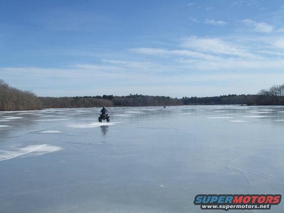 ATV on frozen lake with trees in background