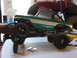 1996 Ford Bronco - An RC car body, painted green and white with large off-road tires, sits on a table.