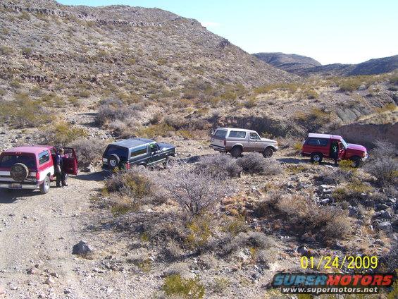 Four 1993 Ford Broncos parked on a dirt road in a desert landscape