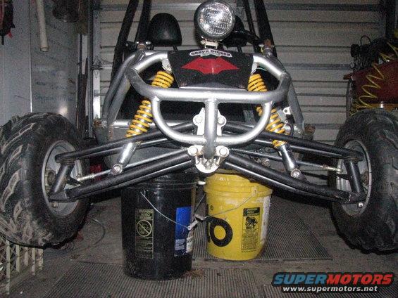 Go-kart front suspension and wheels resting on two buckets