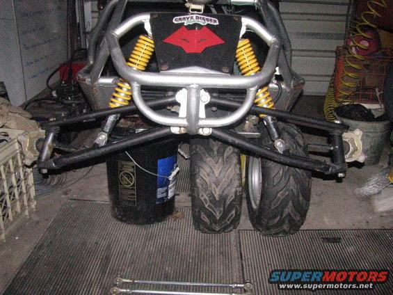 Go-kart rear suspension with yellow shocks and 'Grave Digger' logo