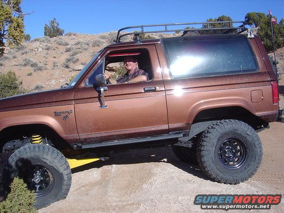 Man driving brown Ford Bronco II off-road