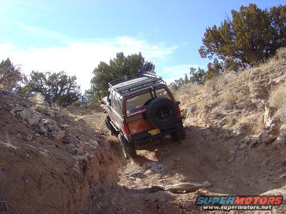Brown 1996 Ford F-250 climbing a steep, rocky dirt trail