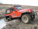 1990 Ford Bronco - This Jeep is stuck in a muddy ditch, with a winch line attached to its front bumper.