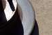 1990 Ford Bronco - A close-up view of a worn brake rotor resting on a gravel surface.
