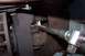 1990 Ford Bronco - Mechanic works on a vehicle's suspension system, focusing on a ball joint area.