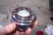 1990 Ford Bronco - A greased ball joint assembly is held in a hand, with a rag and tub of grease visible in the background.