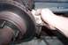 1990 Ford Bronco - A hand cleans a rusty brake rotor with a cloth, likely as part of maintenance.