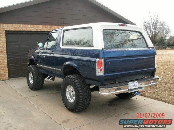 Blue and white lifted 1996 Ford Bronco rear view