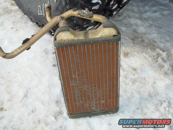 Heater core with bent metal tubes, sitting in snow