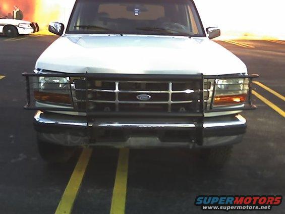 1996 Ford Bronco front with brush guard, parked behind a police car