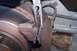 1990 Ford Bronco - Close-up of a vehicle's brake system, showing a caliper and rotor with pliers in use.