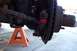 1990 Ford Bronco - Close-up view of a vehicle's ball joint assembly, supported by an orange jack stand.