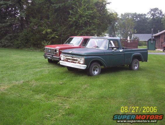 Green 1965 Ford F-100 pickup truck parked next to a red Ford truck
