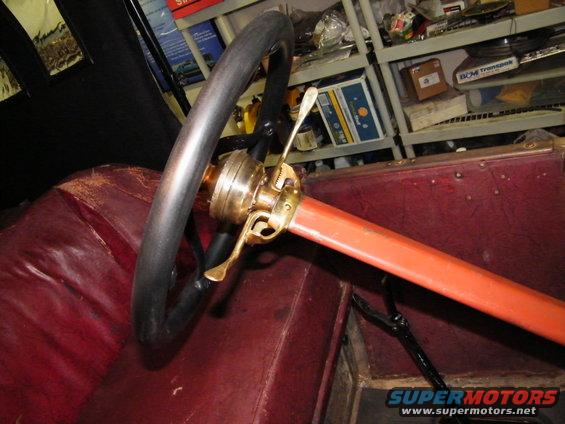 Steering wheel, brass controls, and red leather interior of a 1913 Ford Model T