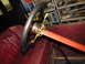 1913 Ford Model T - The interior of a 1913 Ford Model T shows its steering wheel, brass controls, and red leather upholstery.