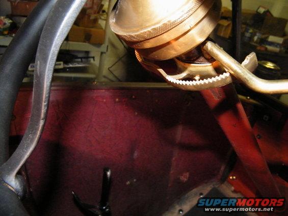 Close-up of a steering wheel and brass fixture inside an old car