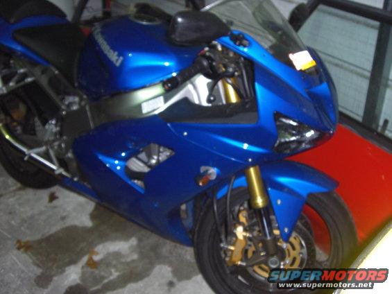 Blue motorcycle with gold front forks and black wheels, parked indoors